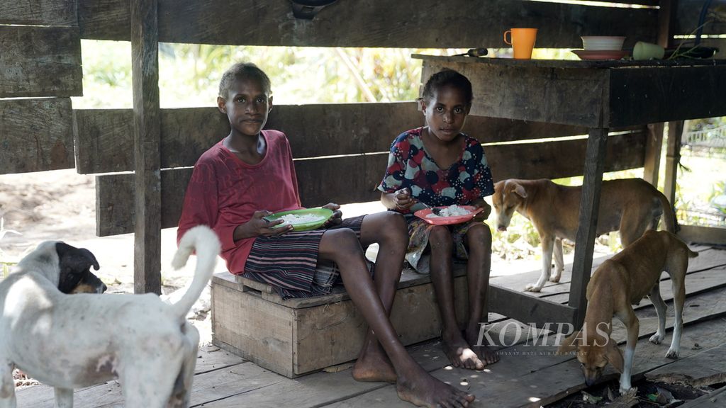 Anak-anak makan nasi putih tanpa lauk atau yang biasa mereka sebut nasi kosong di Kampung Zanegi, Distrik Animha, Kabupaten Merauke, Papua, Kamis (10/11/2022). 
