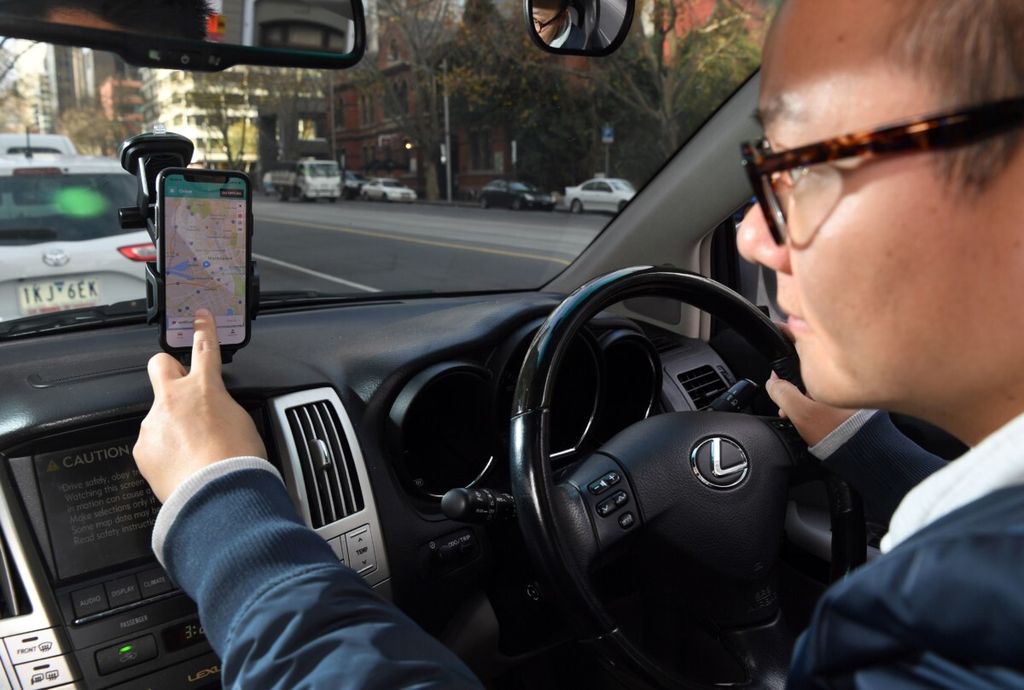 Staf Didi, Jian Lu, memperagakan aplikasi baru produk China, Didi Mobility, Senin (25/6/2018), pada <i>smartphone</i>-nya di Melbourne, Australia. Didi telah meningkatkan penggeraknya untuk bisnis global untuk bersaing dengan Uber, Taxify, dan Ola di pasar taksi Australia.