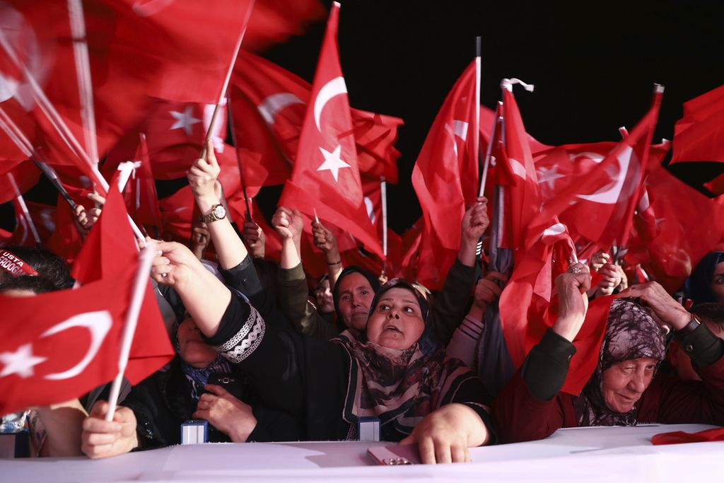 Para pendukung kandidat petahana, Recep Tayyip Erdogan mengibarkan bendera Turki di depan Istana Kepresidenan Turki di Ankara pada Minggu (28/5/2023). Mereka merayakan kemenangan Erdogan.