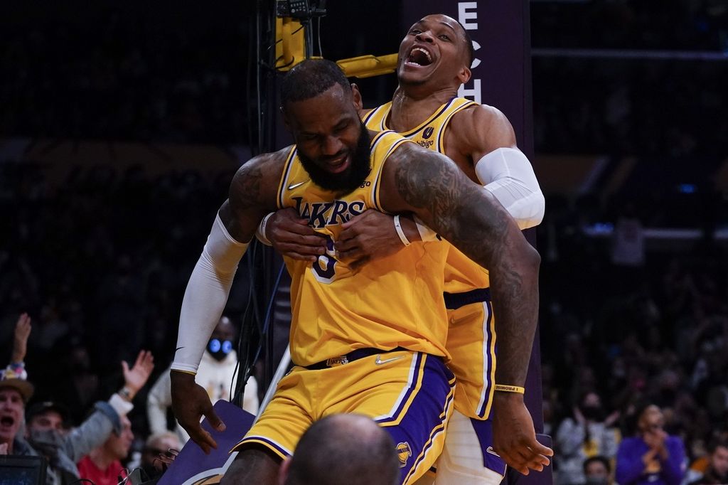 Pemain Los Angeles Lakers, Russell Westbrook (kiri, belakang), membantu rekannya, LeBron James (depan), untuk berdiri setelah terjatuh pada paruh pertama laga NBA melawan Indiana Pacers di Los Angeles, Rabu (19/1/2022).