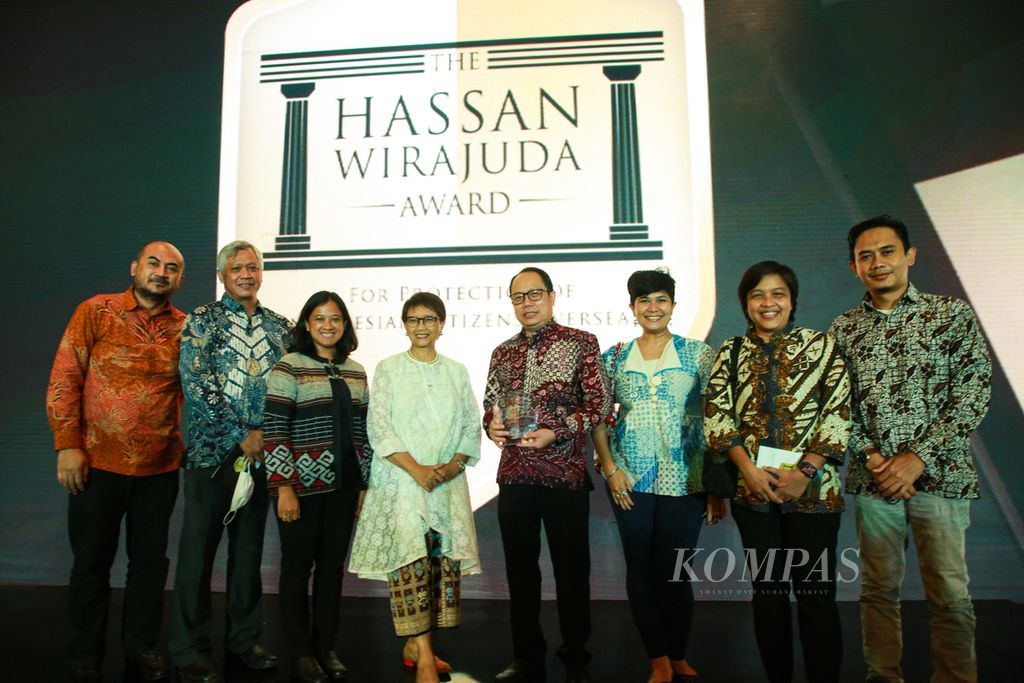 Desk Internasional Harian <i>Kompas </i>menerima Hassan Wirajuda Pelindungan WNI Award 2022 kategori jurnalis/media dalam malam penganugerahan di Jakarta, Senin (9/1/2023). Penghargaan yang disampaikan Menteri Luar Negeri Retno Marsudi (keempat dari kiri) diterima oleh Pemimpin Redaksi Harian Kompas Sutta Dharmasaputra (lima kiri) dan anggota Desk Internasional Harian <i>Kompas</i>.
