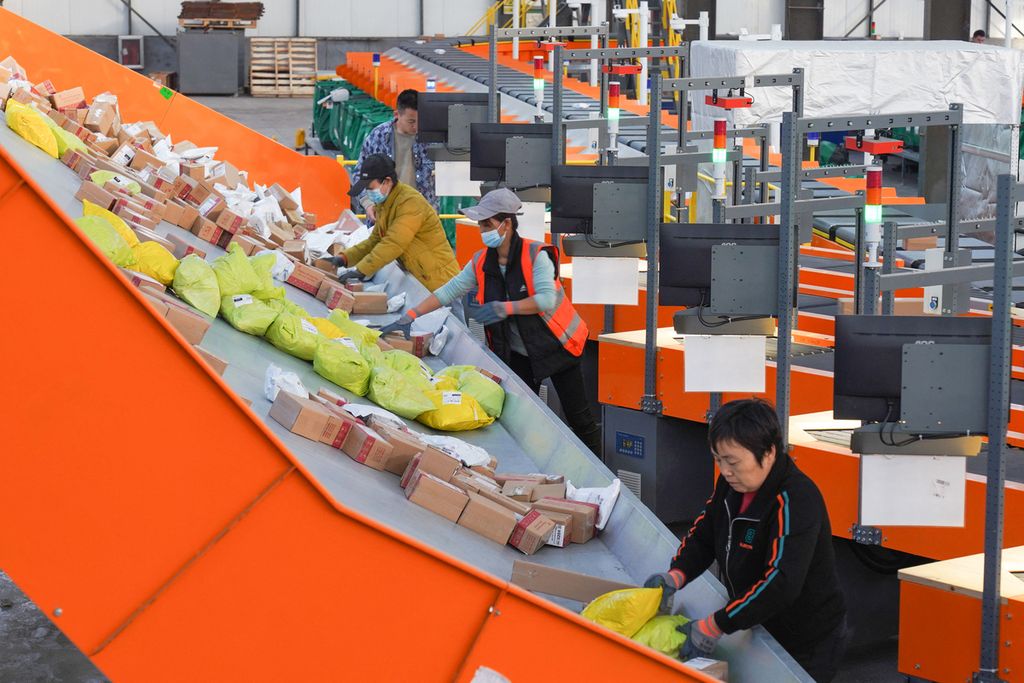 Pekerja memilah paket untuk dikirim menjelang festival belanja Singles Day di pusat logistik di Zouping, Provinsi Shandong, China, Jumat (10/11/2023). 