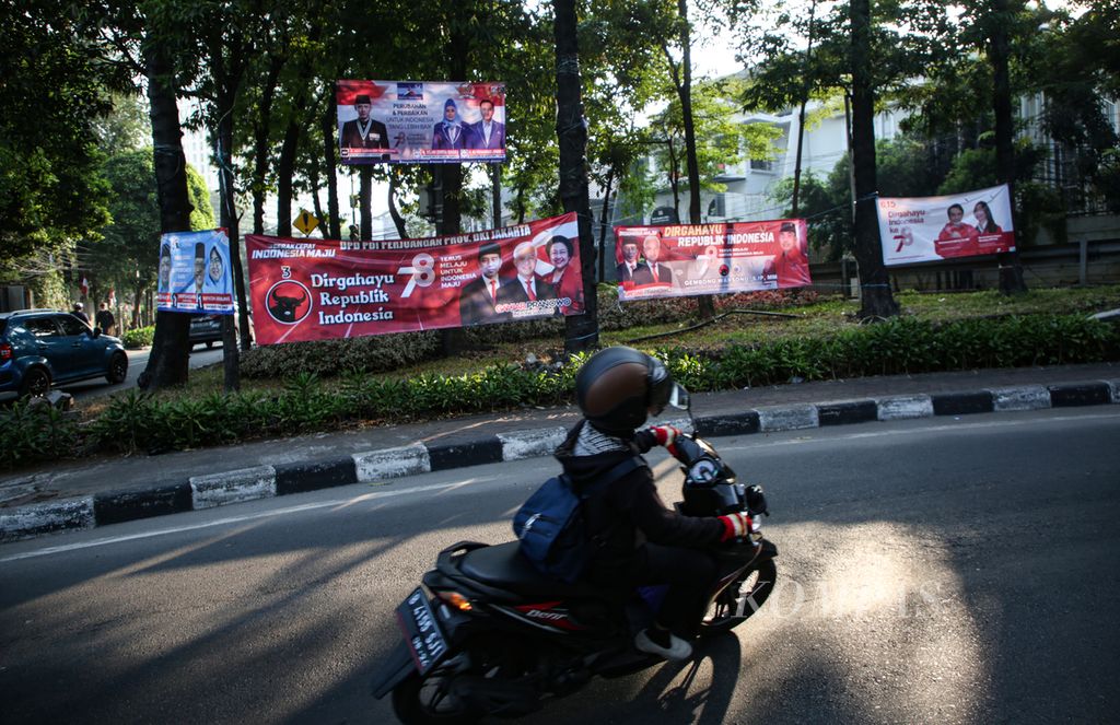 Pengendara sepeda motor melintas di deretan spanduk partai politik dan caleg kawasan Kebayoran Lama, Jakarta Selatan, Sabtu (19/8/2023).