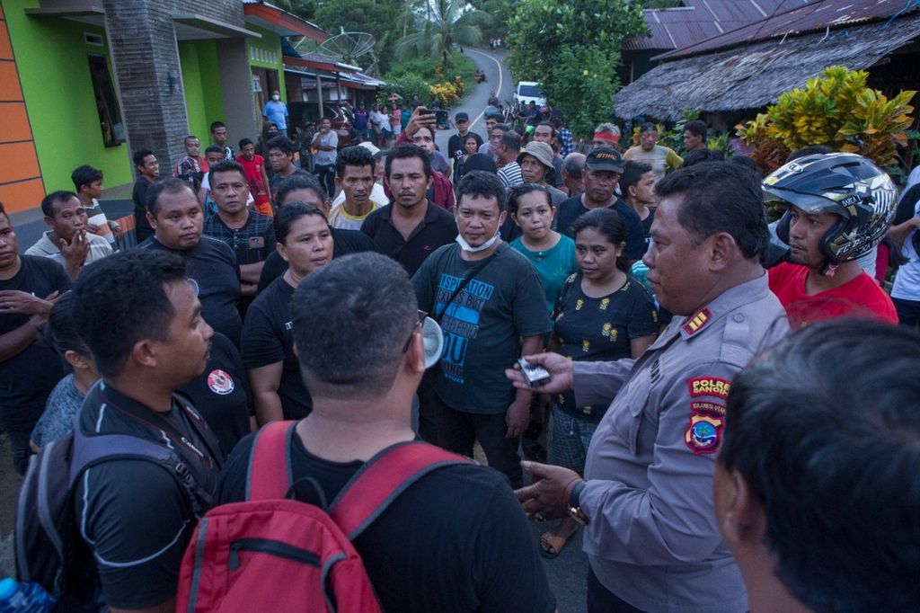 Warga Kampung Bowone dan Binebas berdiskusi dengan pihak kepolisian dalam upaya mengadang akses alat berat pertambangan milik PT TMS di Kepulauan Sangihe, Sulawesi Utara, pada Kamis (16/6/2022).