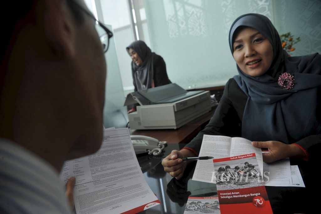 Petugas bank menjelaskan Sukuk Negara Ritel seri SR-003 yang mulai ditawarkan di Bank OCBC NISP, Jakarta, Februari 2011. 
