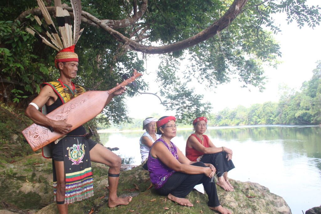 Martha Haran (63), perempuan Desa Datah Diaan, Kabupaten Kapuas Hulu, melantunkan <i>telimaa' </i>syair lagu untuk sungai, diiringi sape' yang dimainkan Siprianus Gunung (51), Selasa (12/11/2019).