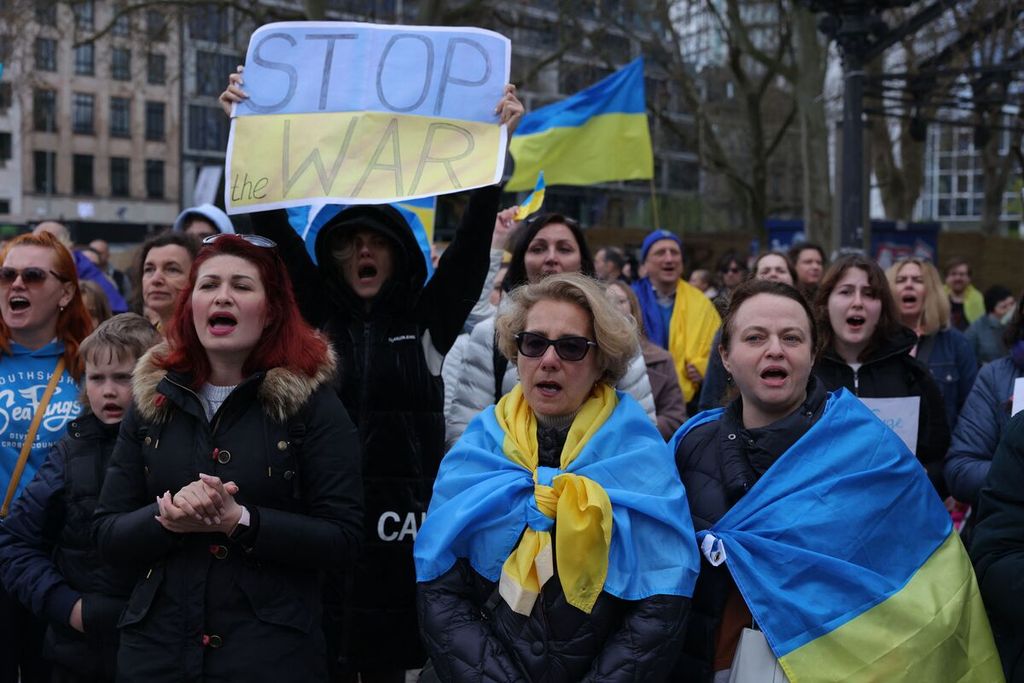 Warga dengan membawa bendera-bendera Ukraina berunjuk rasa menentang pawai pro-Rusia di Frankfurt am Main, wilayah barat Jerman, Minggu (10/4/2022). 