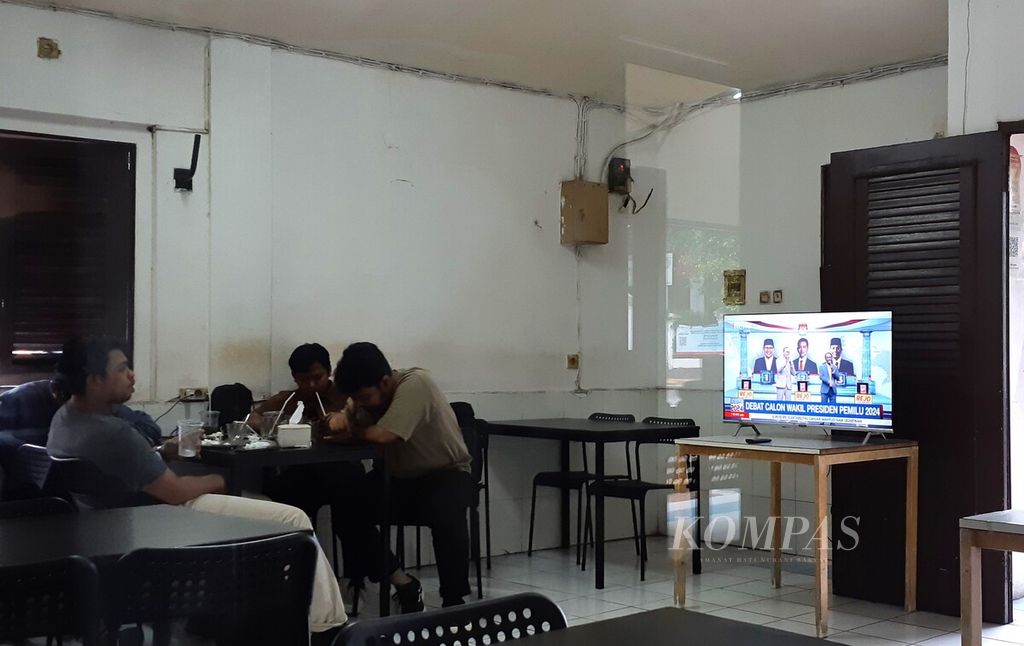 Sejumlah pemuda menonton televisi yang akan menayangkan acara Debat Calon Wakil Presiden 2024 di salah satu warung kopi di Kelurahan Petojo Selatan, Kecamatan Gambir, Jakarta Pusat, Minggu (21/1/2024).