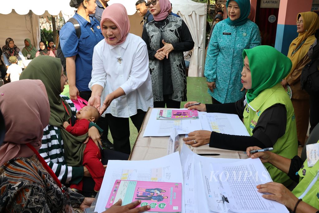 Nyonya Iriana Joko Widodo berinteraksi dengan warga yang membawa bayinya untuk ditimbang berat badannya dan dipantau perkembangannya di RPTRA Taman Sawo, Kebayoran Baru, Jakarta, Selasa (11/6/2024).