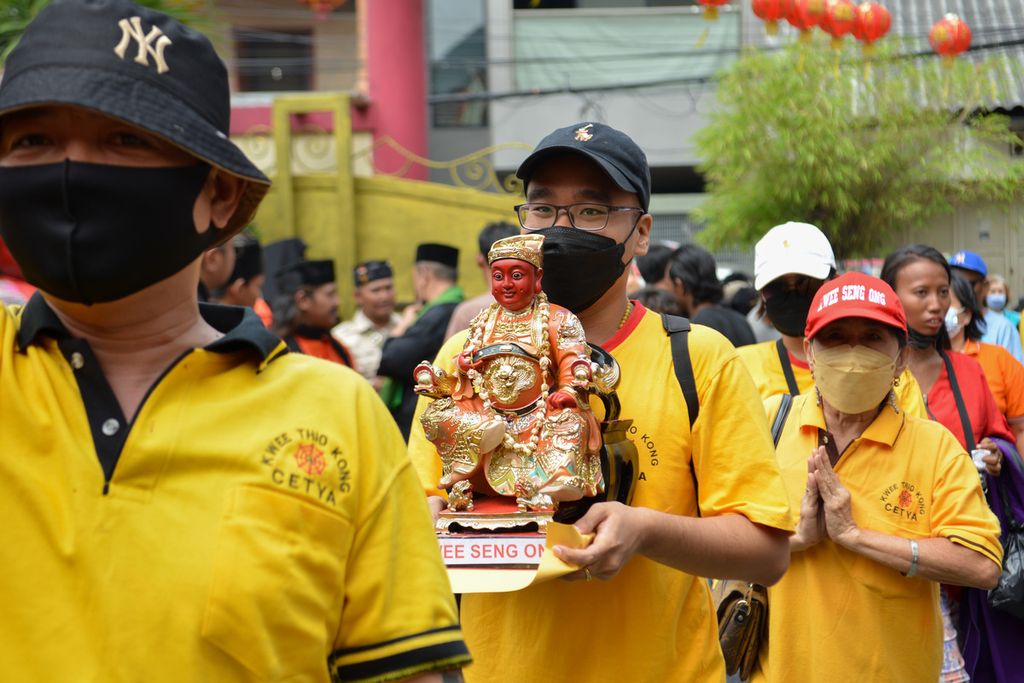 Seorang peserta kirab Toa Pe Kong membawa patung dewa di kawasan pecinan Glodok, Jakarta Barat, Minggu (5/2/2023). 