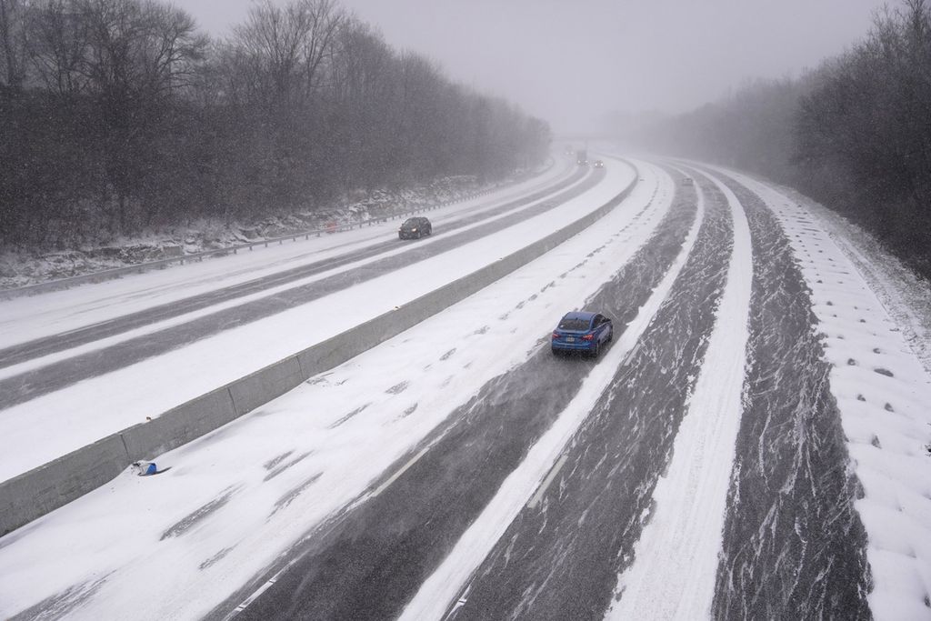 Beberapa kendaraan melintasa di jalur antar kota saat badai salju mulai turun di St Louis pada Kamis (22/12/2022) lalu.