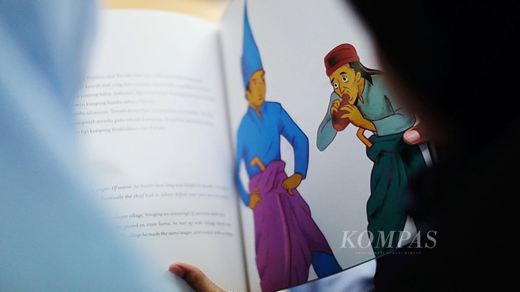 Anak membaca buku cerita <i>Tattadu</i> yang merupakan cerita rakyat dari Sulawesi Selatan. Membaca cerita rakyat dapat menumbuhkan minat anak terhadap karya sastra.