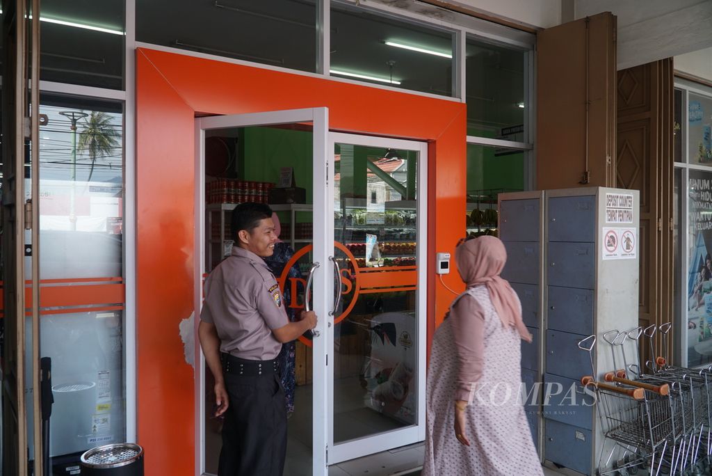 Petugas keamanan membukakan pintu bagi pengunjung di Dalas Swalayan, Jalan Andalas, Kota Padang, Sumatera Barat, Sabtu (18/3/2023). Dalas Swalayan merupakan salah satu ritel modern milik pengusaha lokal yang bergeliat beberapa tahun terakhir.