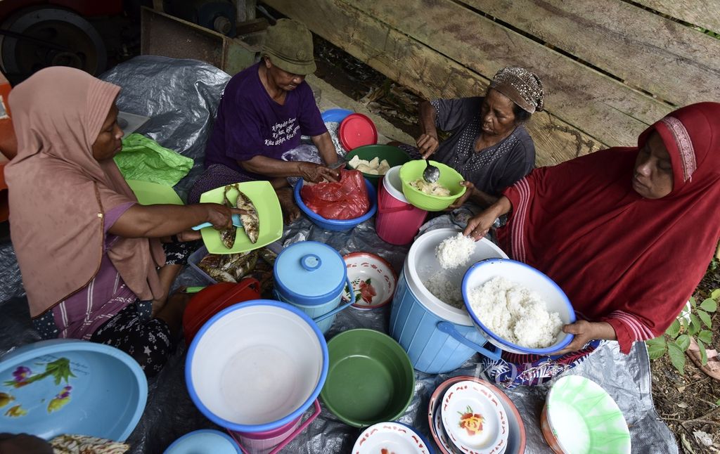 Ibu-ibu menyiapkan makan siang saat waktu istirahat di tengah panen padi di Desa Buton, Pulau Obi, Halmahera Selatan, Maluku Utara, Minggu (26/11/2023). 