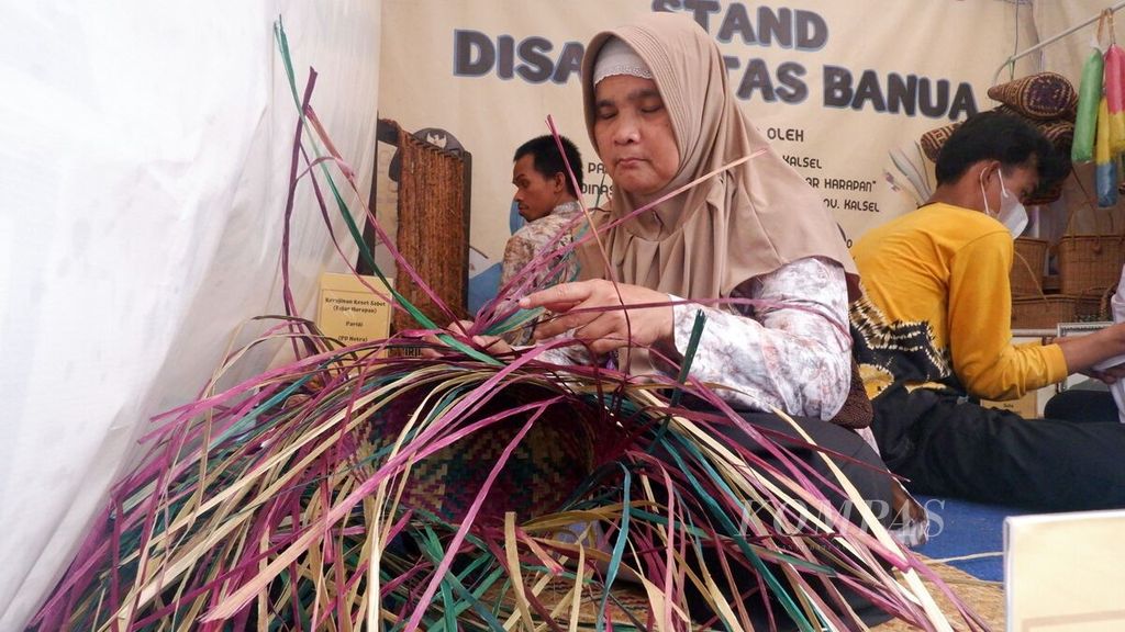 Pengrajin disabilitas membuat anyaman purun di sela-sela pameran produk usaha mikro, kecil, dan menengah (UMKM) dalam kegiatan kampanye Gerakan Nasional (Gernas) Bangga Buatan Indonesia (BBI) di Banjarmasin, Kalimantan Selatan, Jumat (22/7/2022). 