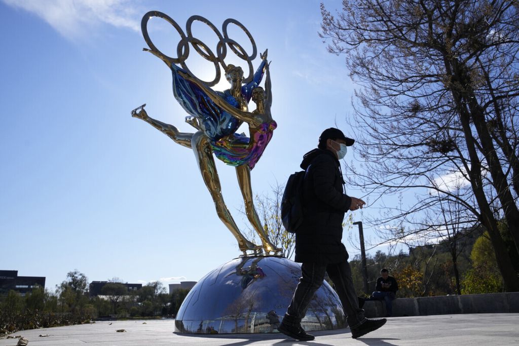 Pengunjung Taman Shougang melintasi patung bertema Olimpiade Musim Dingin Beijing, 9 November 2021. Beberapa jam sebelum pembukaan acara itu, Presiden China Xi Jinping dan Presiden Rusia Vladimir Putin bertemu dan sepakat mempererat kerja sama bilateral. 