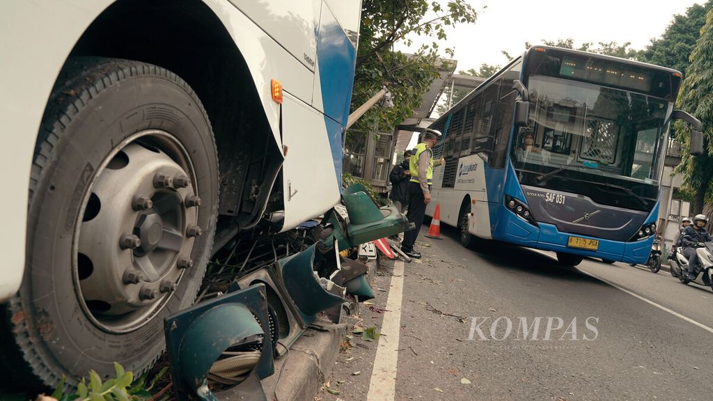 Polisi mengatur lalu lintas di lokasi kecelakaan bus Transjakarta di Jalan I Gusti Ngurah Rai, Duren Sawit, Jakarta Timur, Jumat (11/2/2022). Kecelakaan yang terjadi di dekat halte bus Transjakarta Raden Inten tersebut tidak mengakibatkan korban jiwa. Sopir bus dengan nomor polisi B 7091 PGA yang mengangkut lima penumpang tersebut hilang kendali hingga menabrak median jalan.