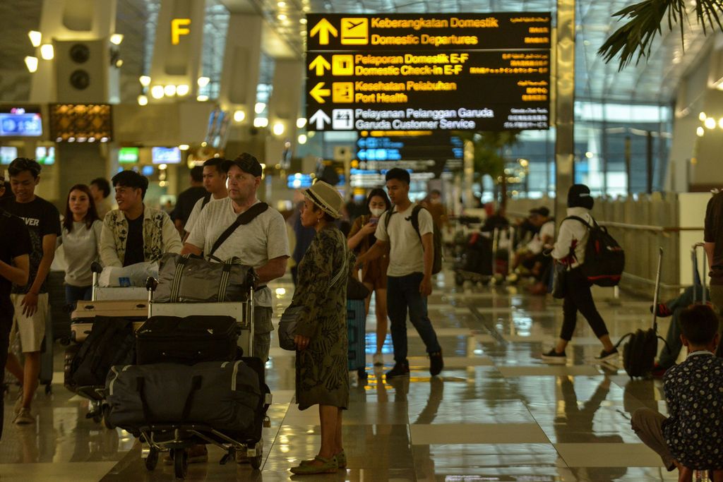 Calon penumpang pesawat berjalan dengan membawa koper dan barang bawaan di Terminal 3 Bandara Internasional Soekarno-Hatta, Tangerang, Banten, Kamis (18/5/2023). 