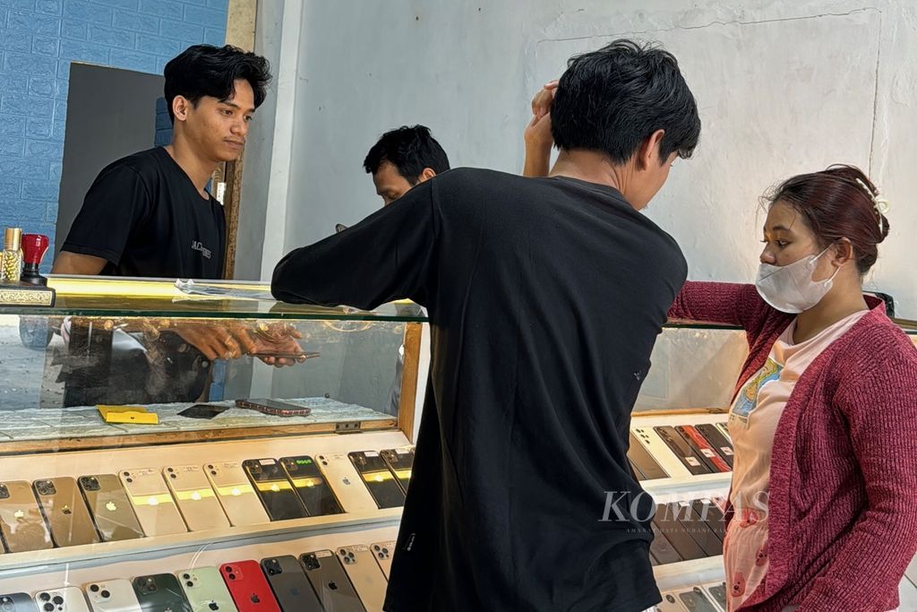 Pengunjung melihat deretan telepon seluler bekas di Toko eBox Mataram di Mataram, Nusa Tenggara Barat, Sabtu (23/3/2024).