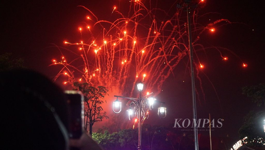 Seorang warga merekam pertunjukan kembang api dalam rangka pergantian tahun, di Balai Kota Surakarta, Jawa Tengah, Minggu (1/1/2023). Momen perayaan serupa tak diadakan dua tahun terakhir akibat pandemi Covid-19 yang sulit dikendalikan. Untuk itu, adanya gelaran tersebut disambut antusiasme tinggi dari segenap masyarakat.
