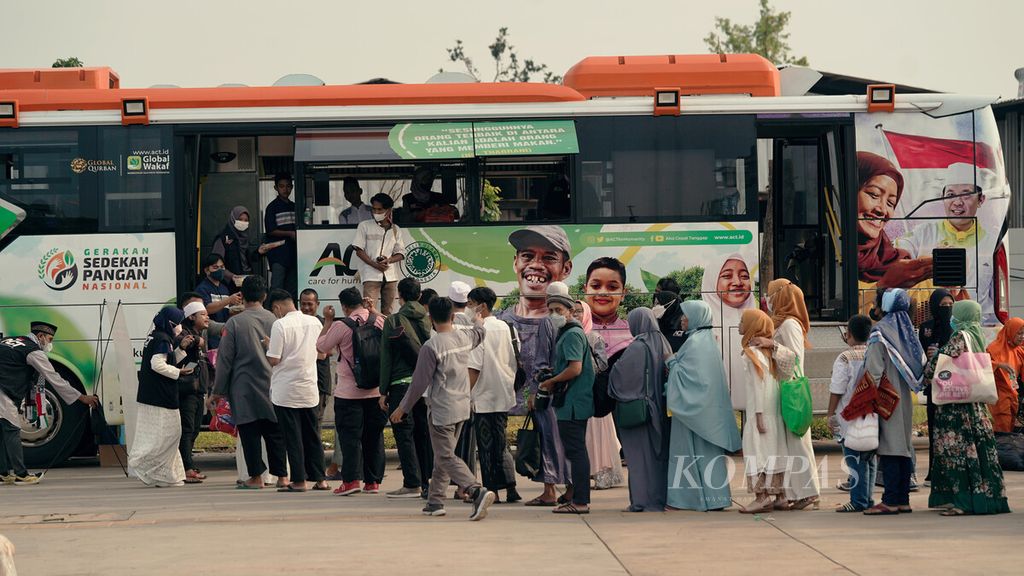 Sukarelawan membagikan makanan dari dalam bus Aksi Cepat Tanggap (ACT) dalam Gerakan Sedekah Pangan Nasional di Kelurahan Papanggo, Tanjung Priok, Jakarta Utara, Senin (2/5/2022).