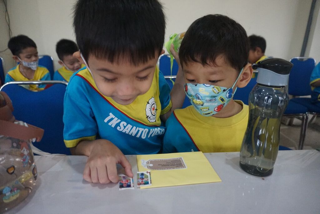 Anak-anak TK Santo Yosep menempel prangko bergambar foto diri mereka saat berkunjung ke Kantor Pos Purwokerto di Kabupaten Banyumas, Jawa Tengah, Kamis (2/3/2023).