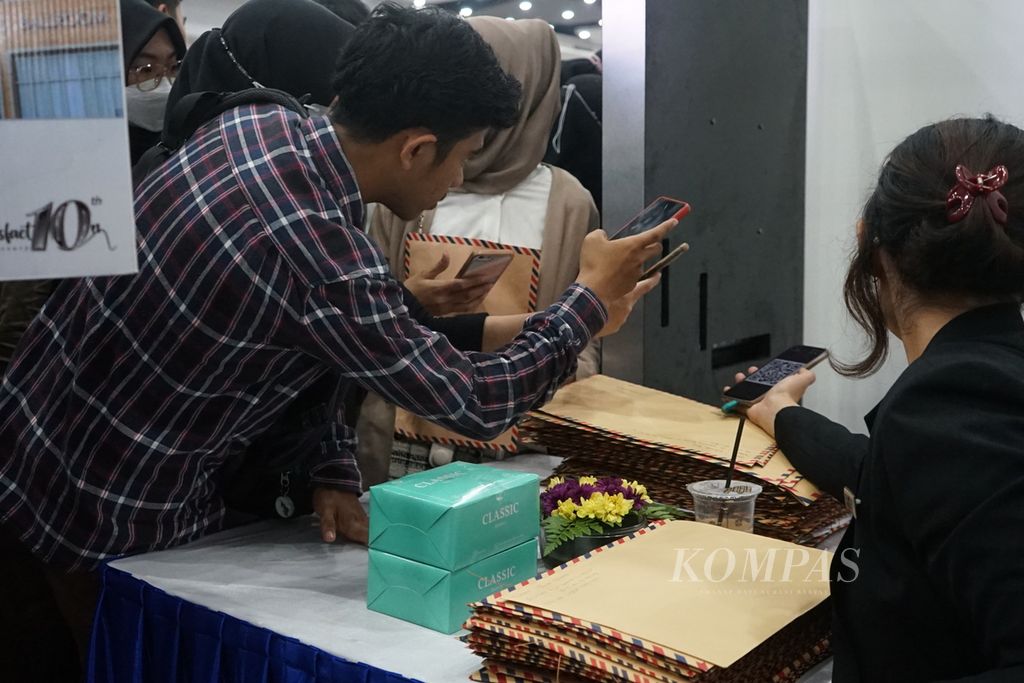 Sejumlah pelamar kerja sedang memindai kode batang di salah satu perusahaan perhotelan yang membuka lowongan di bursa kerja yang digelar di Palembang, Sumatera Selatan, Rabu (7/6/2023). 