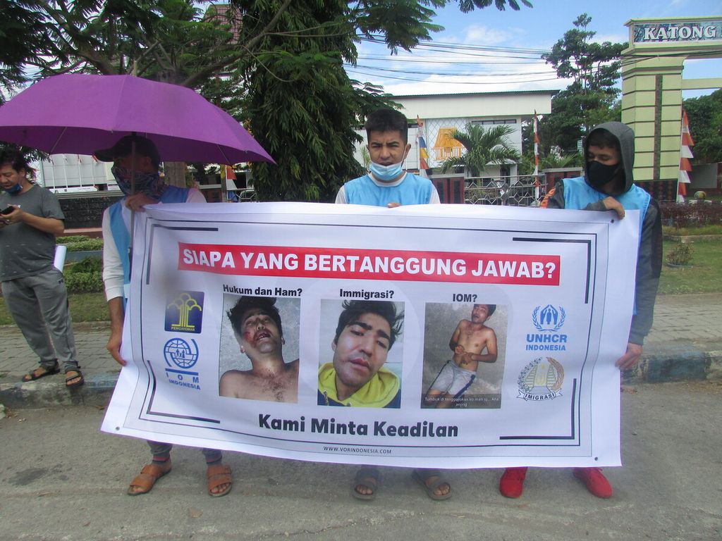 Spanduk korban penganiayaan, Hasan Rizal Haidari, yang diduga dilakukan petugas imigrasi Kupang, dibawa para demonstran di Kupang, Senin (27/6/2022).