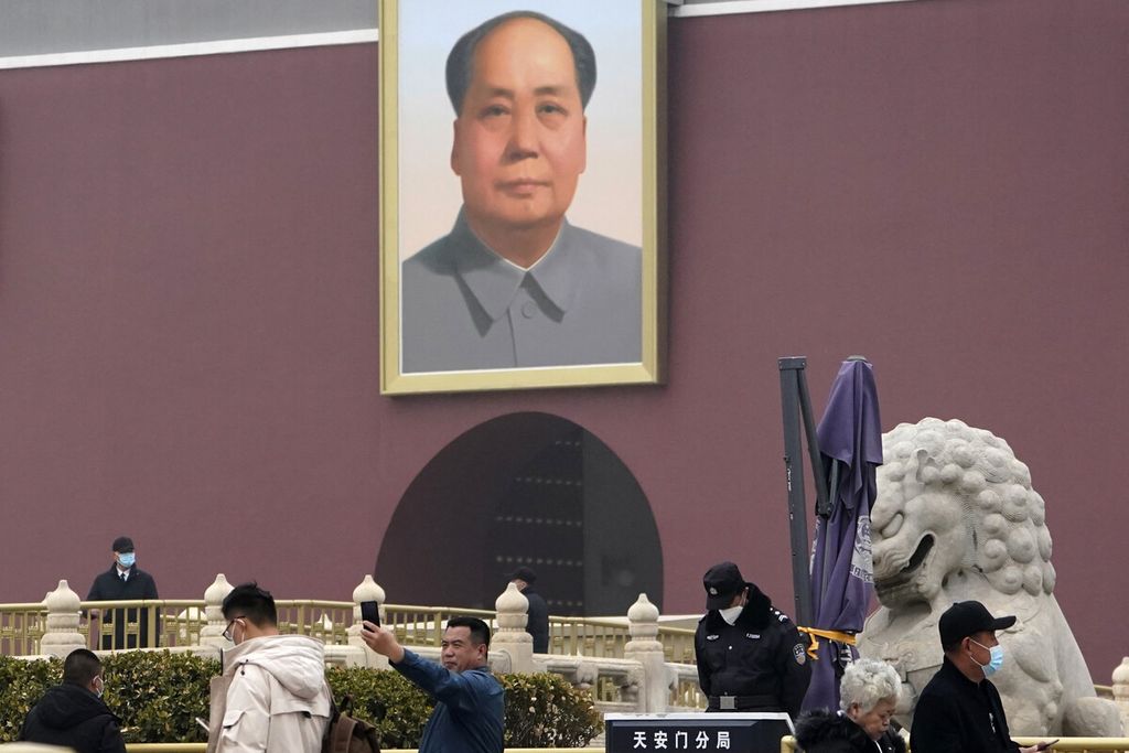 A man took a selfie near a portrait of the late leader Mao Zedong at Tiananmen Gate, near the Great Hall of the People where the annual National People's Congress is held, in Beijing on Friday (5/3/2021).
