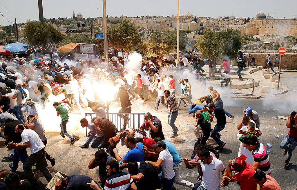 Demonstran  asal Palestina berlarian menghindari gas air mata yang ditembakkan tentara Israel, Jumat (21/7).  Presiden Palestina Mahmoud Abbas memerintahkan agar semua kontak dengan Israel di semua tingkatan ditangguhkan.