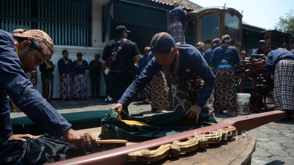 Abdi dalem Keraton Yogyakarta membersihkan bagian dari kereta Nyai Jimat yang dicuci dalam tradisi jamasan di Museum Kereta Keraton, Yogyakarta, Selasa (2/10/2018).
