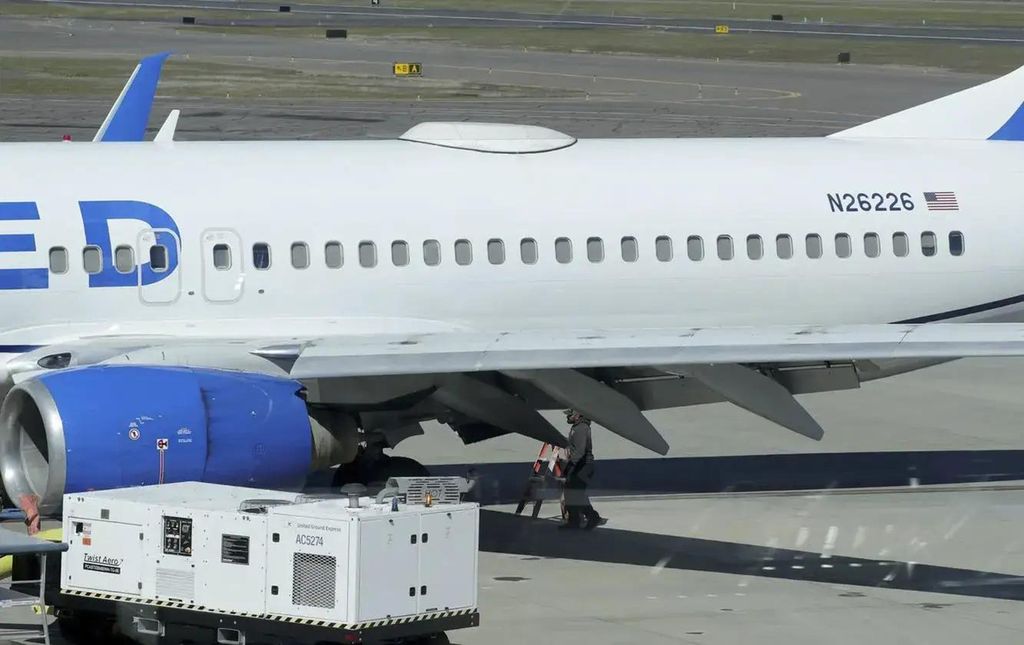 Seorang petugas berjalan di bawah pesawat United nomor penerbangan 333 yang menggunakan pesawat jenis Boeing 737-824 di Bandara Medford, Oregon, Jumat (15/3/2024). Sebuah panel yang menghubungkan sayap dan bodi pesawat dilaporkan hilang saat penerbangan antara San Francisco dan Oregon.