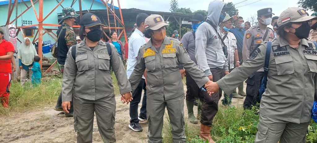 Petugas menjaga alat berat yang merobohkan rumah warga di lahan konflik masyarakat dengan PT Perkebunan Nusantara III di Kelurahan Gurilla, Kecamatan Siantar Sitalasari, Kota Pematang Siantar, Sumatera Utara, Jumat (25/11/2022).