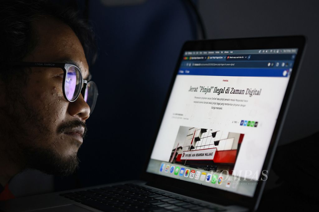 Ilustrasi warga membaca berita terkait pinjaman online (pinjol) di Jakarta, Selasa (14/11/2023). 