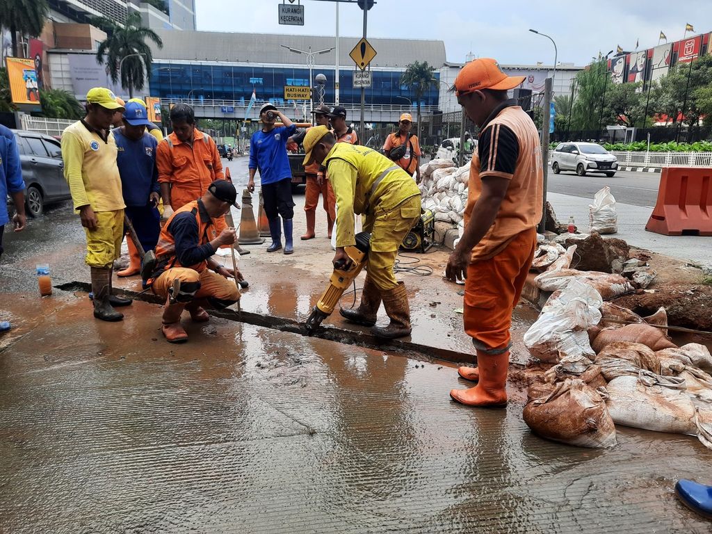 Para pekerja gabungan dari Suku Dinas Bina Marga dan Sumber Daya Air Jakarta Selatan membongkar jalan untuk pemasangan pipa di depan Mal Pondok Indah 2, Jakarta, Jumat (17/3/2023).