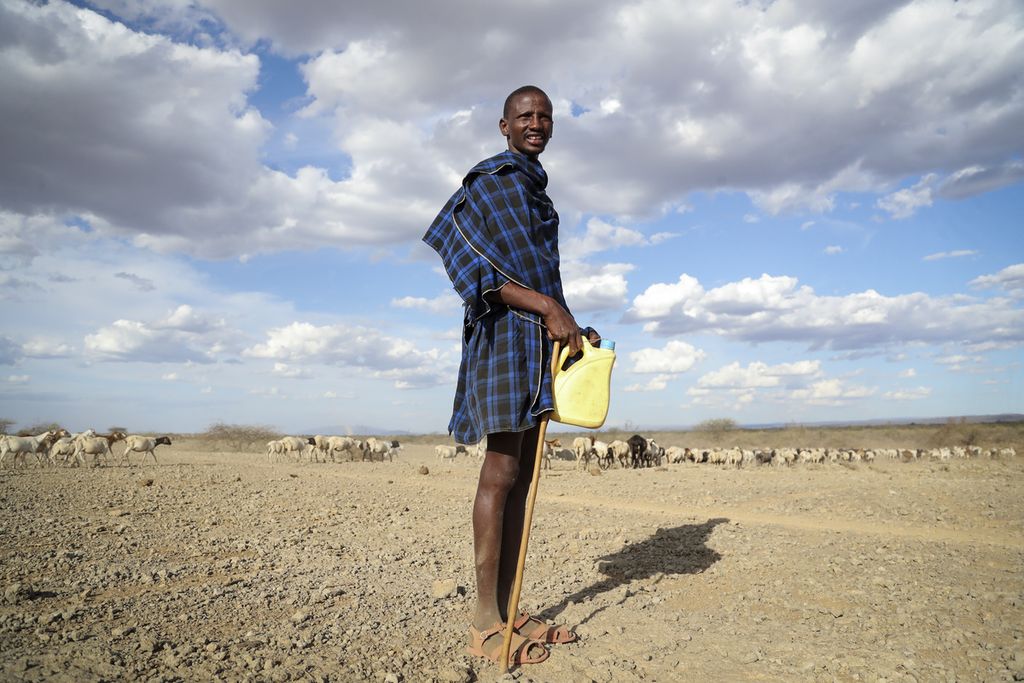A Maasai man in Kenya walks with his livestock in search of grasslands in Ilangeruani Village, near Lake Magadi in Kenya (11/9/2022). Several parts of Kenya routinely experience very long dry seasons and clean water crises.