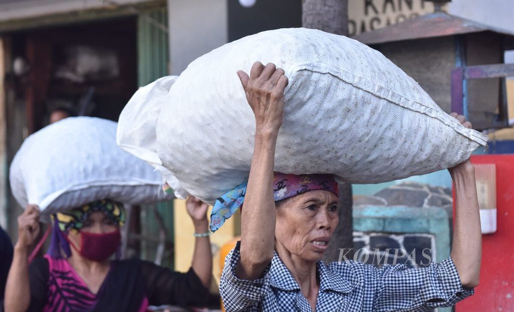 Aktivitas perempuan buruh di Pasar Pabean, Kota Surabaya, Jawa Timur, Senin (23/5/2022). Untuk membawa barang, mereka mendapat bayaran Rp 500 hingga Rp 5.000 tergantung berat bawaan yang mereka bawa. 