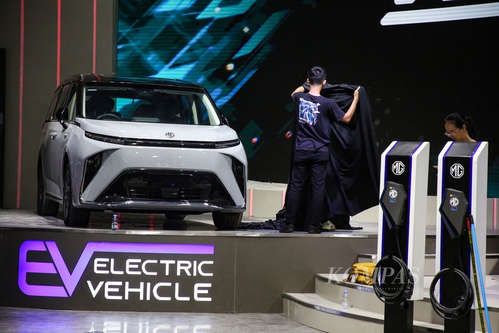 Pekerja mempersiapkan mobil listrik yang akan dipamerkan dalam pameran otomotif Indonesia International Motor Show (IIMS) 2024 di JIExpo Kemayoran, Jakarta, Selasa (13/2/2024).