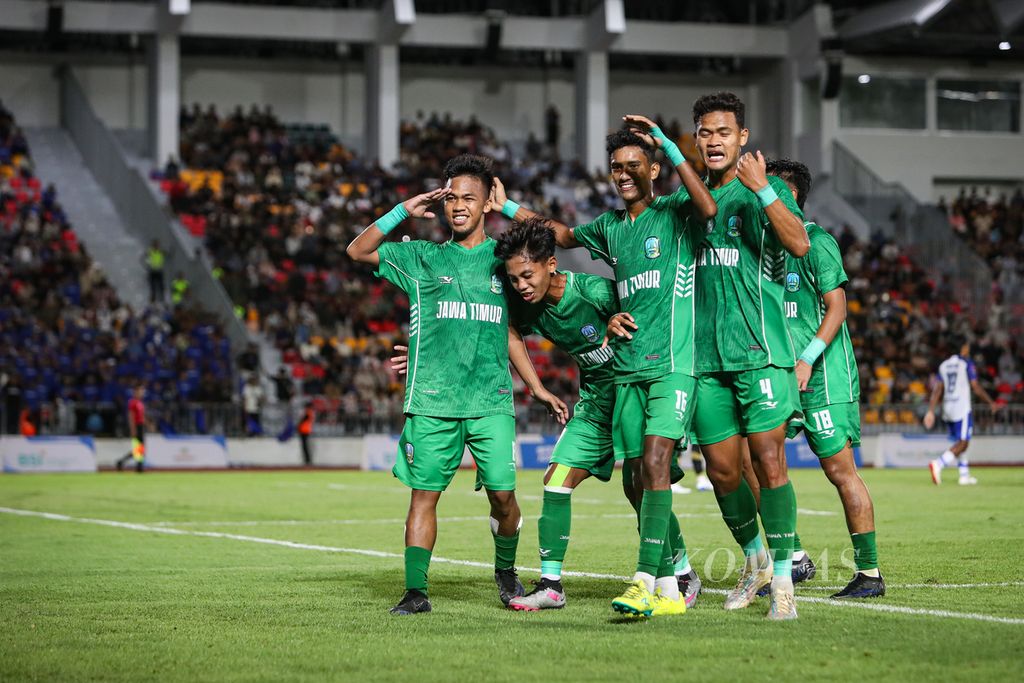 Pemain Jawa Timur, Rano Jutati (kiri), melakukan selebrasi bersama rekan timnya setelah mencetak gol lewat tendangan penalti ke gawang Jawa Barat pada final sepak bola PON Aceh-Sumut 2024 di Stadion Harapan Bangsa, Banda Aceh, Rabu (18/9/2024).