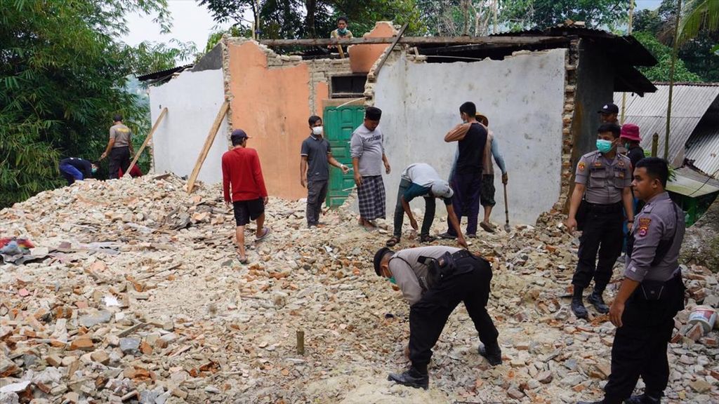 Warga dibantu anggota Polres Banten bergotong royong merobohkan bangunan rumah Marsani (55) yang rusak akibat gempa. Hal tersebut dilakukan untuk mengantisipasi timbulnya korban akibat tertimpa bangunan.