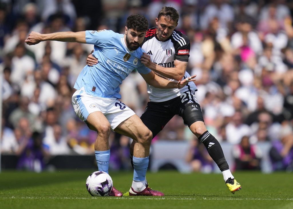 Bek Manchester City, Josko Gvardiol, berebut bola dengan pemain Fulham, Timothy Castagne, dalam laga Liga Inggris antara Fulham dan Manchester City di Stadion Craven Cottage, London, Sabtu (11/5/2024). Manchester City memastikan gelar juara liga apabila menang atas Tottenham Hotspur, Rabu (15/5/2024) dini hari WIB, dan West Ham United, Minggu (19/5/2024).