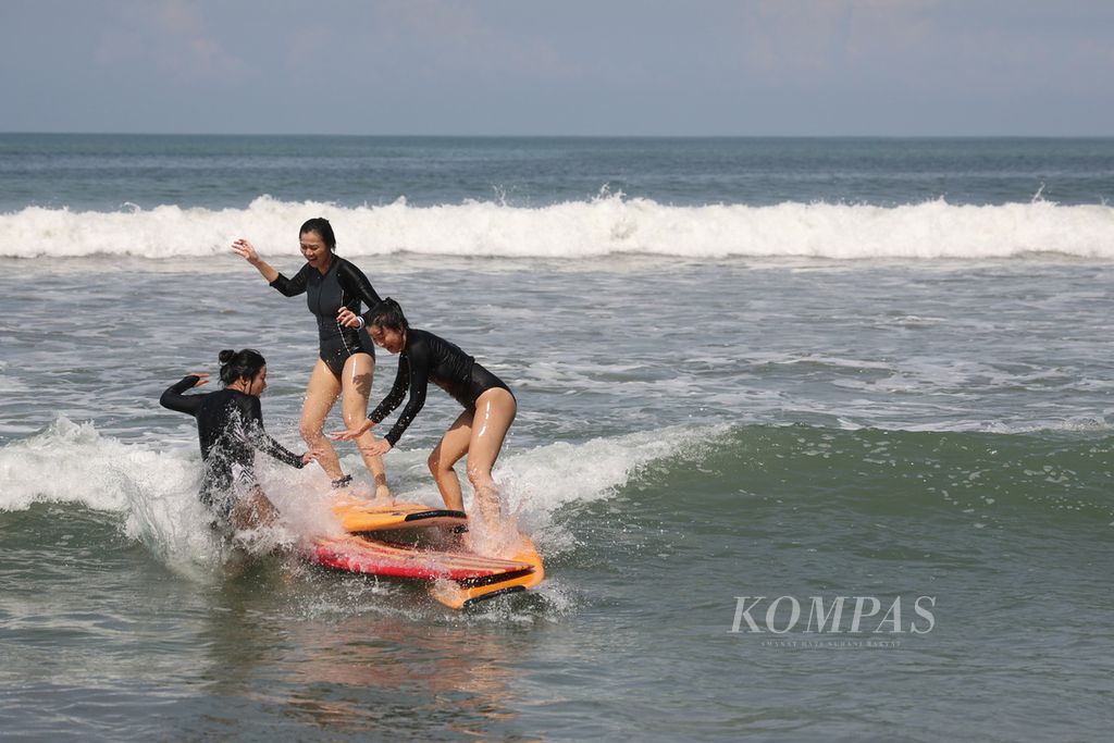 Turis bertabrakan saat mengikuti kursus berselancar di Pantai Kuta, Bali, Jumat (11/11/2022). 