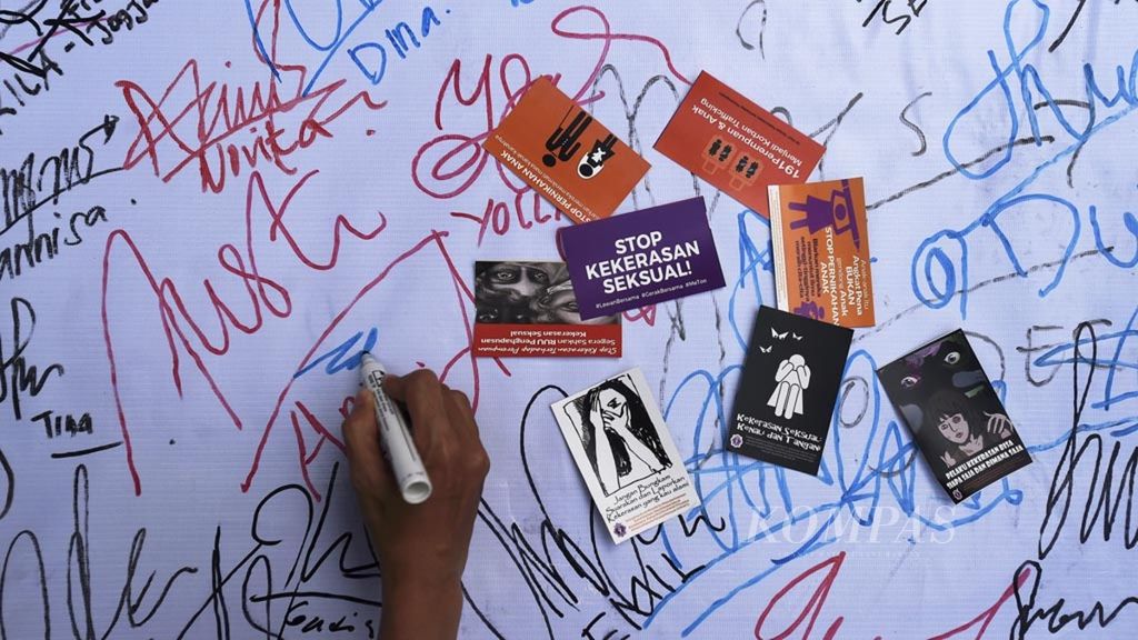 Warga membubuhkan tanda tangan saat aksi damai tolak kekerasan seksual pada perempuan, di Jalan Darmo, Surabaya, Jawa Timur, Minggu (9/12/2018). Mereka mendesak untuk segera disahkannya RUU Penghapusan Kekerasan Seksual.