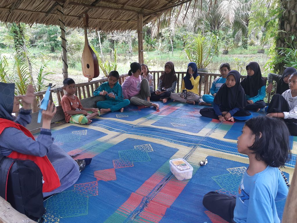 Anak-anak Taman Baco Atap Rumbe mendengarkan dongeng yang dibawakan pegiat literasi Detty Herawati, di Desa Jambi Tulo, Minggu (6/11/202).