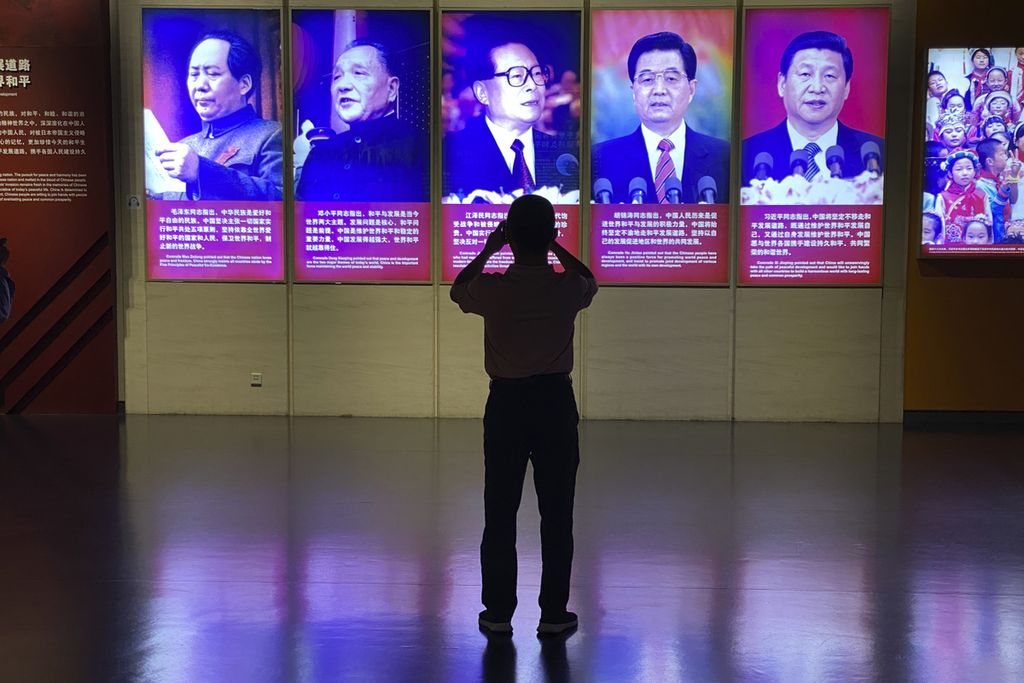 Seorang pengunjung museum mengambil foto <i>potter </i>Presiden China Xi Jinping dan para pendahulunya di Beijing, 27 September 2022. 