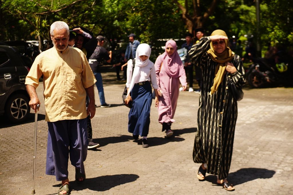 M Yaqub M Karim (61, kiri), Aqila Douraiyah (51, kanan depan), Tahanan PBB II alias Sakinah (12, berseragam), dan Amira Mustafa (51, berbaju merah jambu) berjalan meninggalkan Universitas Sam Ratulangi, Manado, Sulawesi Utara, setelah menghadiri acara wisuda Amar, 9 Februari 2023. Amar adalah anak sulung Yaqub dan Amira.