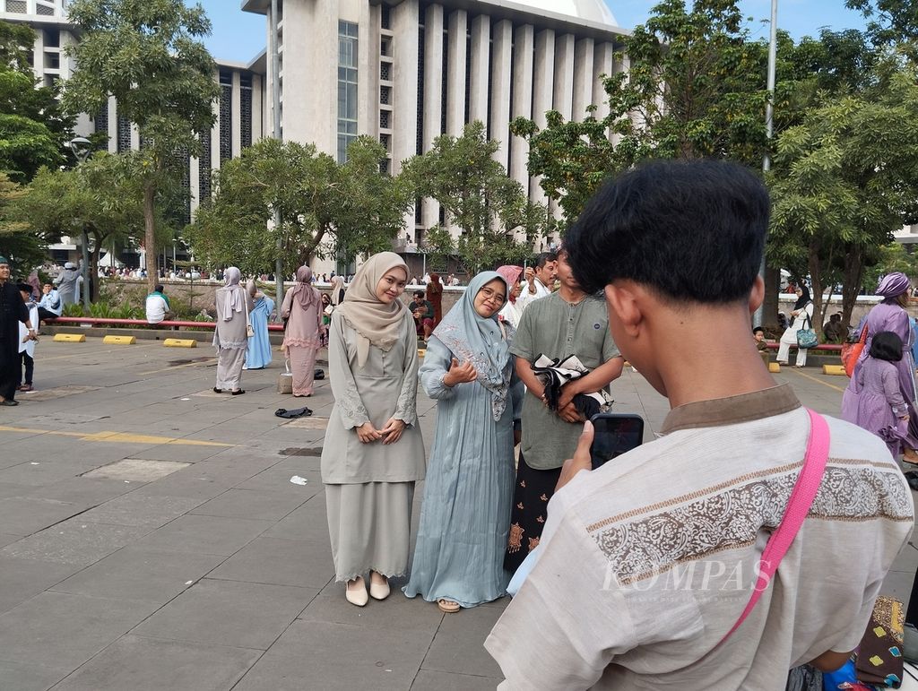 Sebagian umat Islam berfoto di halaman Masjid Istiqlal, Jakarta, seusai shalat Idul Fitri, Rabu (10/4/2024) pagi.