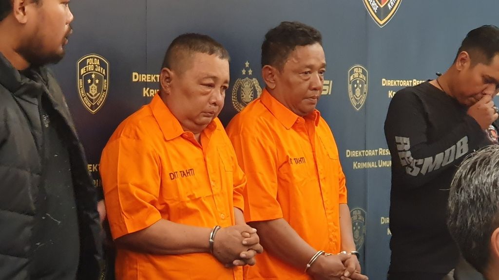 Volly Willy Aritonang (53) dan adiknya, Mohammad Furqon (52), mengenakan baju tahanan saat dirilis di Polda Metro Jaya, Jakarta, Selasa (30/5/2023). 