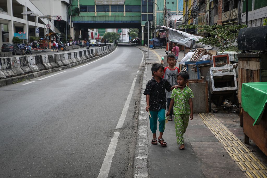 Anak-anak melintasi warung yang tutup di kawasan Pasar Tanah Abang, Jakarta Pusat, Minggu (23/4/2023). Pasar Tanah Abang dan sejumlah toko di sekitarnya tutup saat hari kedua Lebaran 2023. 