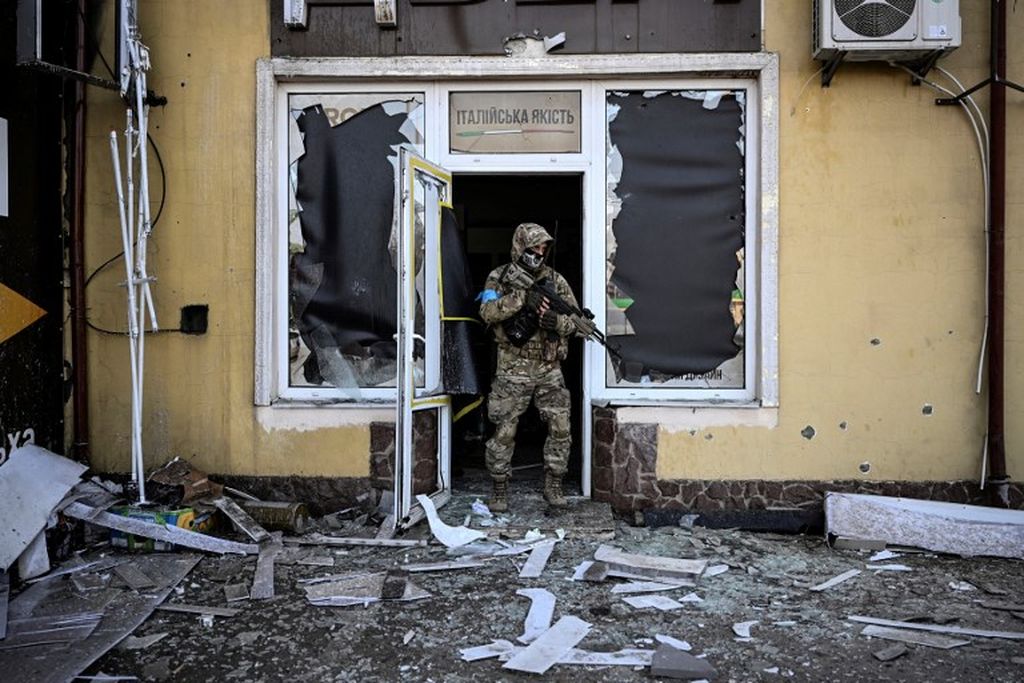 Seorang prajurit Ukraina keluar dari gedung yang telah hancur dibombardir militer Rusia  di Kiev,  12 Maret  2022. 